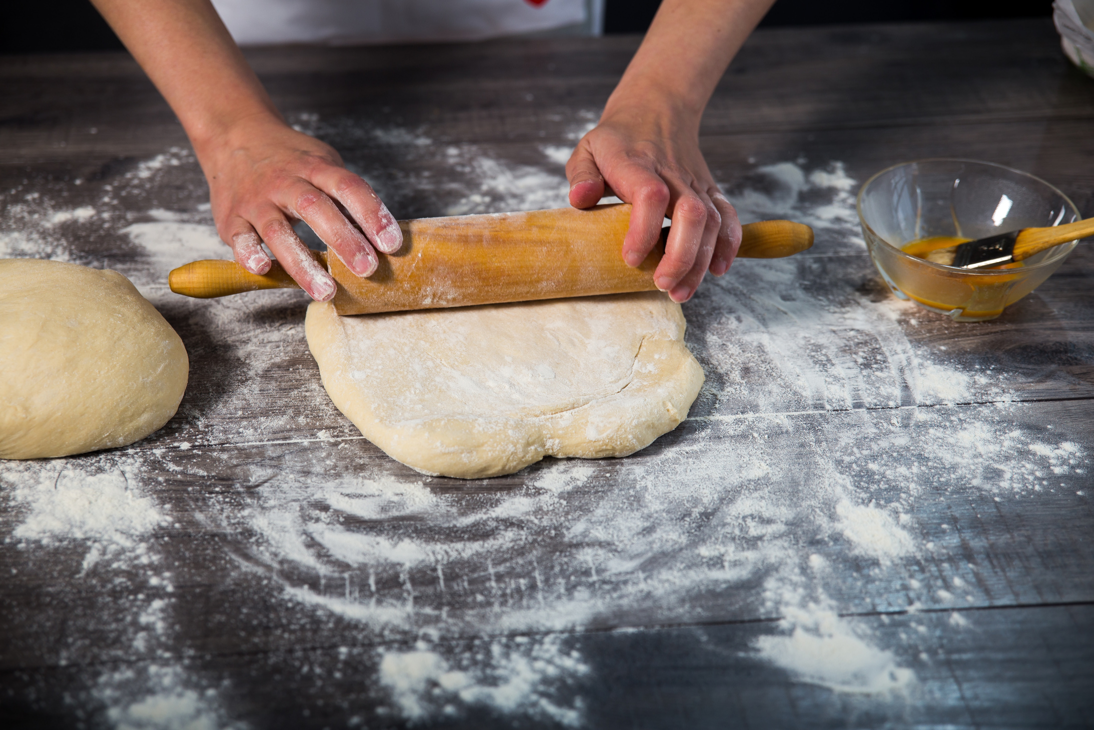 Hands baking dough with rolling pin